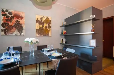 a dining room with a black table and chairs at Divine View Apartment in Rome