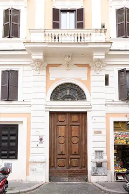 a building with a wooden door and a balcony at Colosseo Apartment - Domus Claudinae in Rome