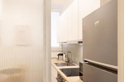 a kitchen with a sink and a refrigerator at Colosseo Apartment - Domus Claudinae in Rome