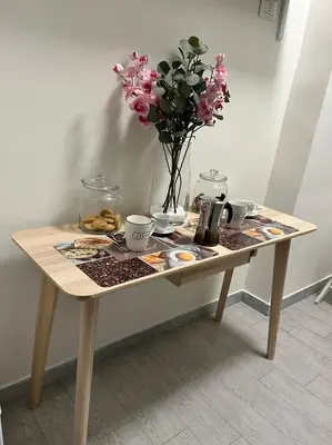 a wooden table with a vase of flowers on it at lucky home in Trastevere in Rome