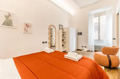 a bedroom with an orange bed and a chair at Cozy Rome - Newly Renovated Apartment near Vatican City in Rome