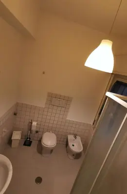 a bathroom with a toilet and a sink and a lamp at Kea Alloggio Turistico in Rome
