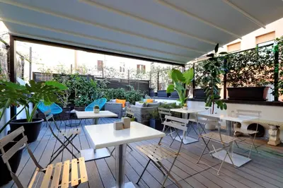 a patio with tables and chairs and plants at Vico Rooms and Terrace in Rome