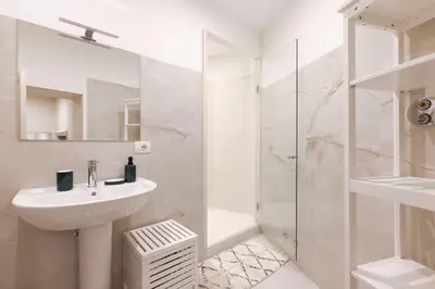 a white bathroom with a sink and a shower at Coppelle Charme in Rome
