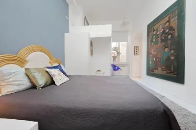a bedroom with a large bed and a painting on the wall at Beautiful Monti apartment Panisperna in Rome