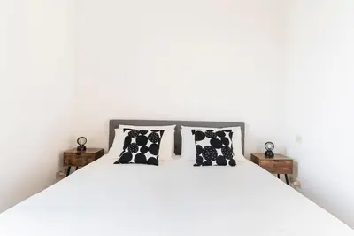 a white bed with black and white pillows on it at Principe House, Central Rome, 3 bedroom 2 bath, Elegant Apartment full of Light in Rome