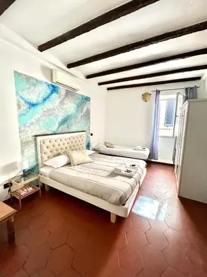 a bedroom with two beds and a painting on the wall at Cellini apartments in Rome