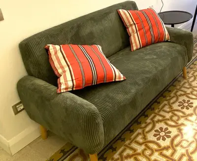 a green couch with two striped pillows on it at Monti Lovely Suite in Rome