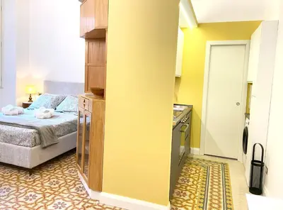 a small bedroom with a bed and a kitchen at Monti Lovely Suite in Rome