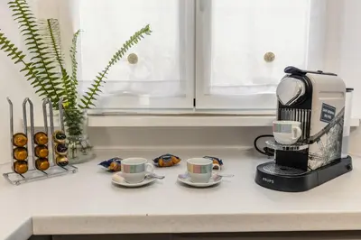 a coffee maker and two cups on a counter at Br1tannia 36 in Rome