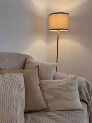 a lamp sitting next to a couch with pillows at Casa Umbertina in Rome