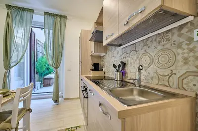 a kitchen with a sink and a table and a window at SweetgardenTrastevere in Rome