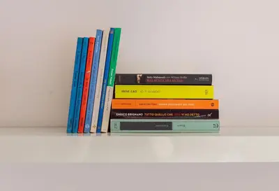 a stack of books sitting on a shelf at Vintage Charm & Comfort - Garbatella in Rome