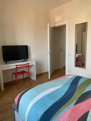 a bedroom with a bed and a desk with a television at Duck House Gemelli in Rome