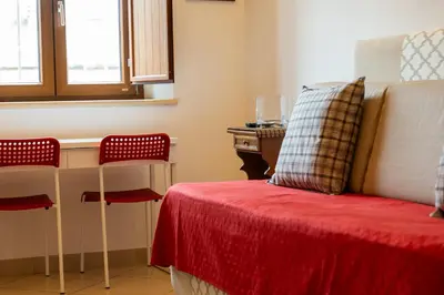 a room with a bed with a red blanket and a desk at kis inn affitacamere guesthouse in Rome