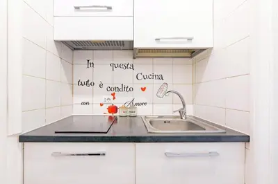 a kitchen with white cabinets and a sink at Renè home - Ponte Milvio in Rome