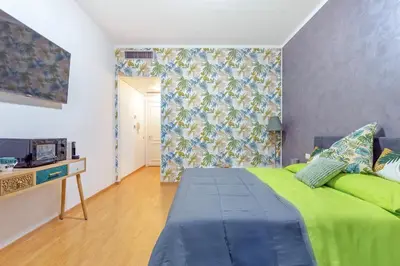 a bedroom with a green bed and a wall at Renè home - Ponte Milvio in Rome