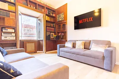 a living room with a couch and a tv on the wall at Elegantis La ParioLina Apartment in Rome