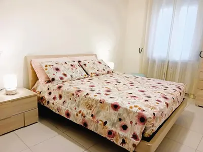 a bedroom with a bed with a floral comforter at BIBI San Giovanni Roma in Rome