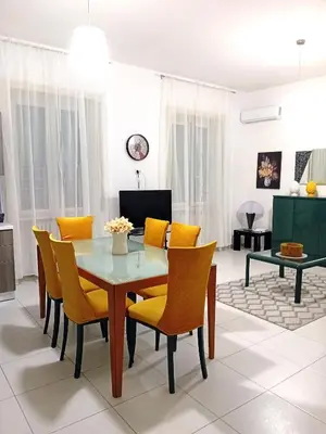 a dining room with a table and yellow chairs at BIBI San Giovanni Roma in Rome