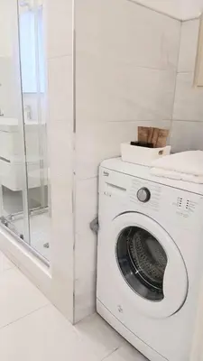 a white washing machine in a bathroom with a shower at BIBI San Giovanni Roma in Rome