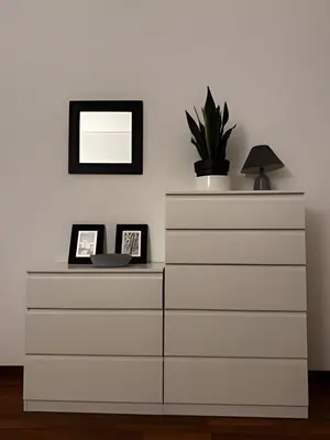 a white dresser with a mirror and a plant on it at Casa verde di Mia in Rome