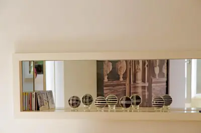 a shelf with a mirror with someousandousandousandousandousandousandousandousandousand at Colosseo nei Fori Imperiali by Luxury Getaways in Rome