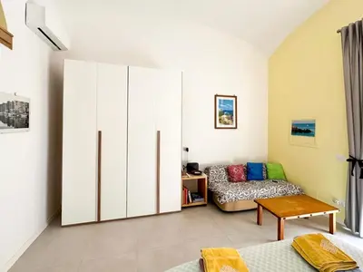 a living room with a large white cabinet and a couch at Nuovo monolocale a 15 minuti dalla Stazione Termini in Rome