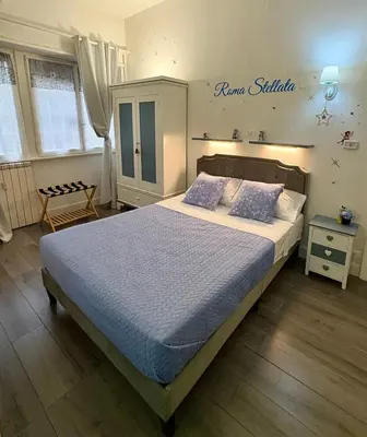a bedroom with a bed with a blue comforter at Roma Stellata in Rome