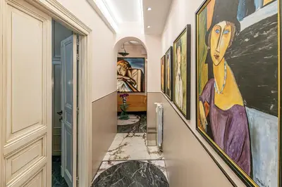 a hallway with paintings on the walls at Tu chiamale emozioni 3 suite in Rome