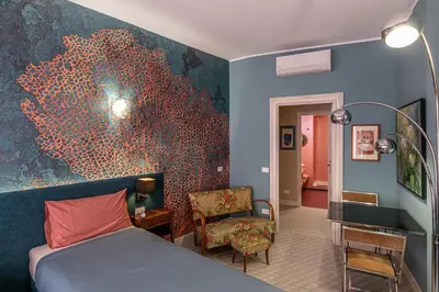 a bedroom with a bed and a painting on the wall at Tu chiamale emozioni 3 suite in Rome
