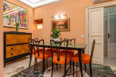 a dining room with a table and chairs at Tu chiamale emozioni 3 suite in Rome