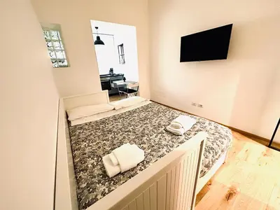 a bedroom with a bed with a tv on the wall at Posto del Cuore in Rome