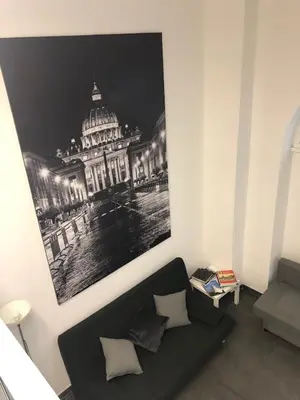 a living room with a black couch and a picture of a building at Loft in old town near Termini Station and University in Rome