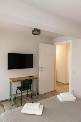 a bedroom with a desk and a television on a wall at DODO Casa e appartamento per vacanze in Rome