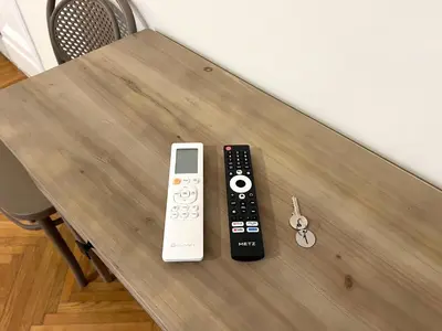 two remote controls sitting on top of a wooden table at Marbel's Rooms in Rome