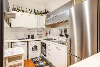 a kitchen with white cabinets and a stainless steel refrigerator at Giulia Apartment in Rome
