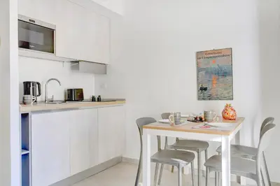 a kitchen with a table and chairs in a room at Vatican Loft with Balcony - Home and More in Rome