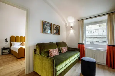 a room with a green couch and a window at Daplace - Costanza Apartment in Rome