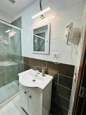 a white bathroom with a sink and a shower at Viktoria House Rome in Rome