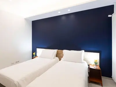 two beds in a room with a blue wall at BNB Ostiense in Rome