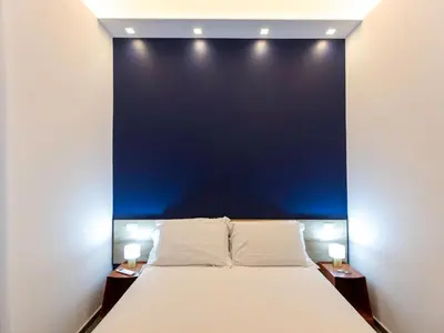 a bed in a room with a blue wall at BNB Ostiense in Rome