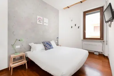 a white bedroom with a white bed and a window at Hip Pad in Garbatella in Rome