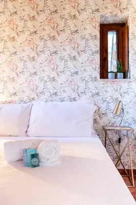 a bedroom with a white bed with a flowery wall at ZENO 13 Paradiso - Casa Verde in Rome