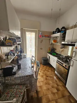 a kitchen with a table and a stove top oven at CS Banco Apartment in Rome