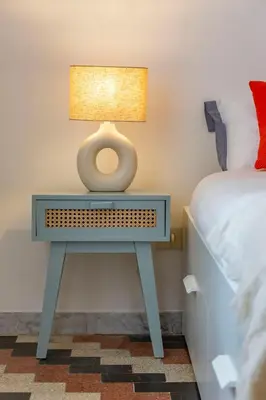 a table with a lamp on it next to a bed at Domus Ana- Modern Elegance, steps away from the colosseum and the historic center in Rome