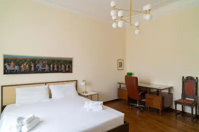 a bedroom with a bed with white sheets and a desk at Ampio appartamento A 500 mt dai musei Vaticani in Rome