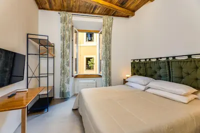 a bedroom with a bed and a desk and a window at New home trastevere in Rome