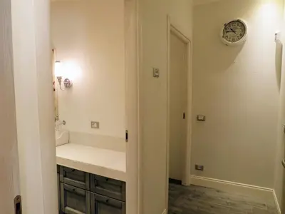 a bathroom with a sink and a clock on the wall at Casa Francesca in Rome
