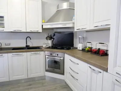 a kitchen with white cabinets and a stove top oven at Casa Francesca in Rome